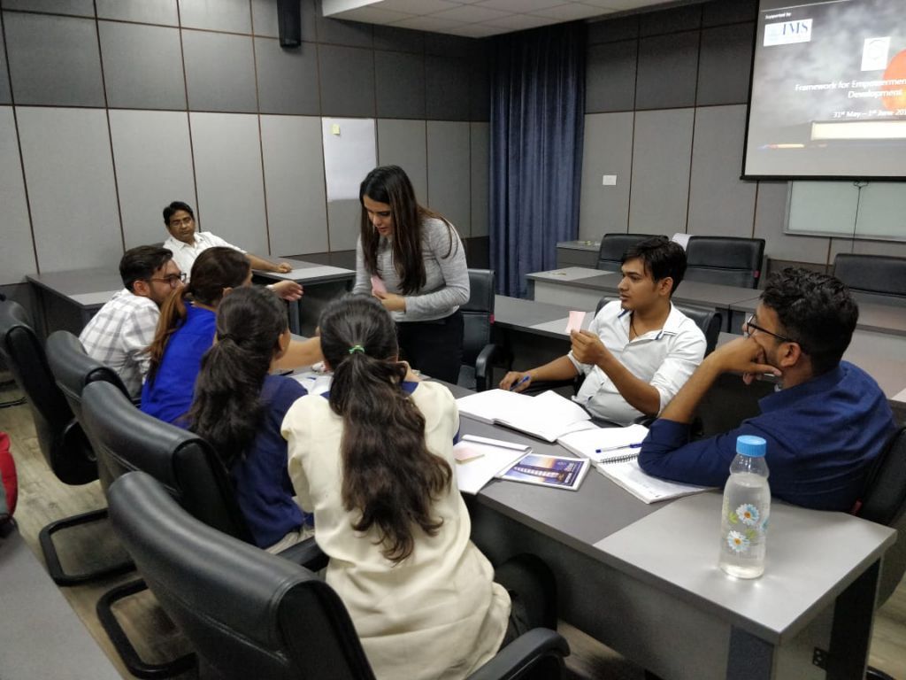 Students around a table working with sticky notes while a peer guides the discussion